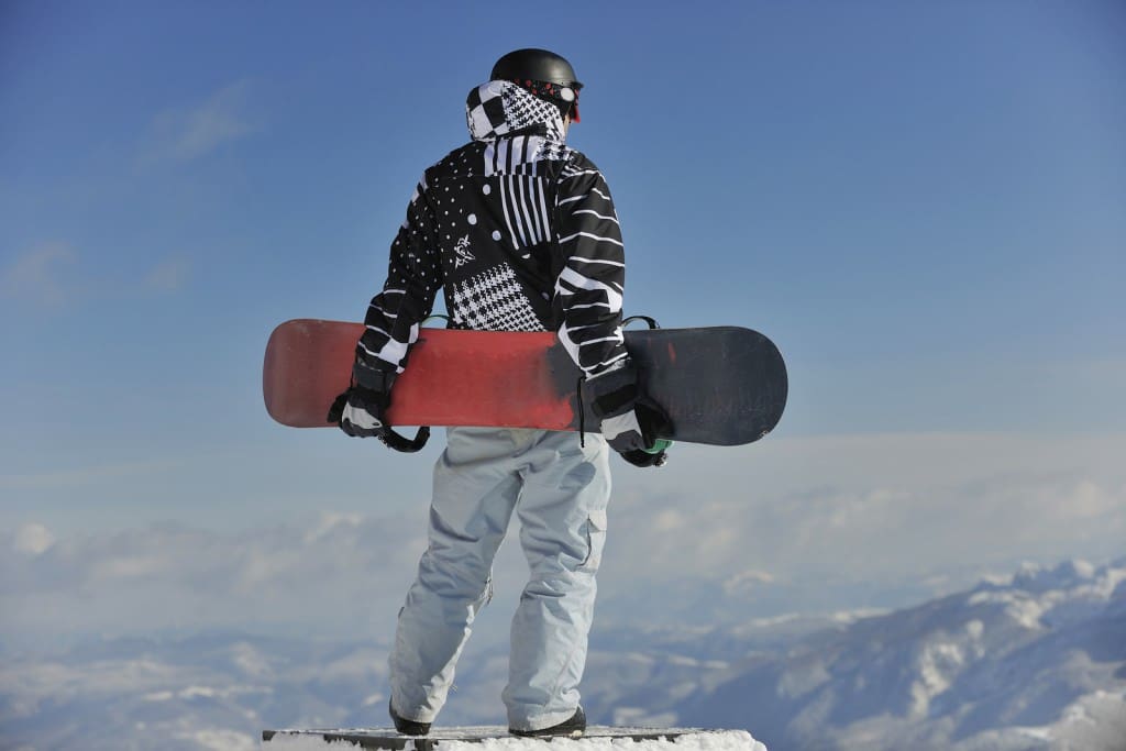 Snowboarder practising mindfulness at the top of a mountain