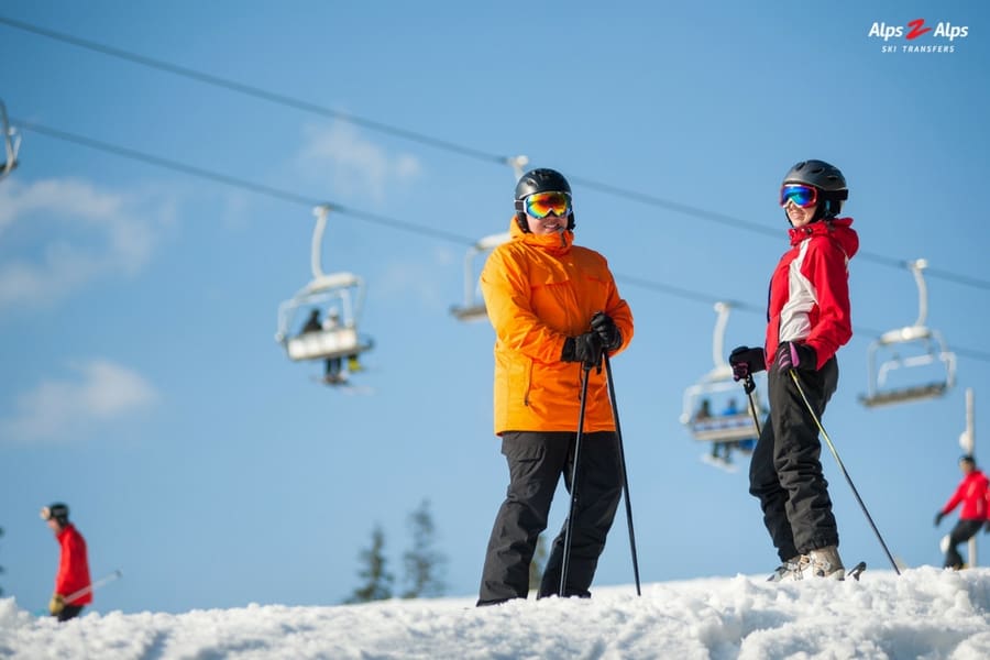 Skiers standing on a slope holding ski poles